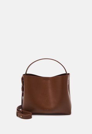 Sac à main en cuir marron avec une poignée supérieure courbe et une bandoulière réglable placée à côté sur un fond blanc.