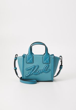 Liten turkise håndveske i teksturert skinn, med et brodert logo i kursiv, to topphåndtak og en avtagbar skulderrem.