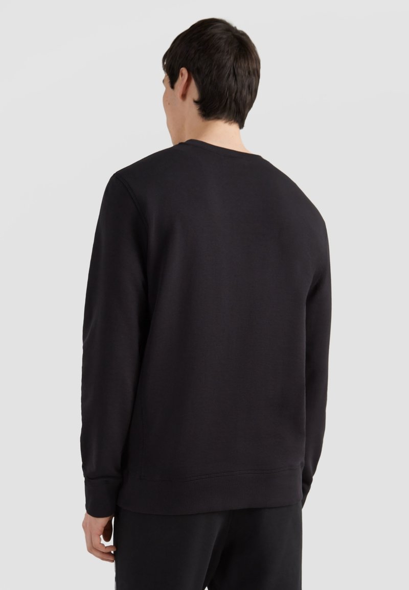 Sudadera negra hecha de una suave tela texturizada. Diseño de cuello redondo con puños y dobladillo acanalados. Presenta una silueta simple y limpia.