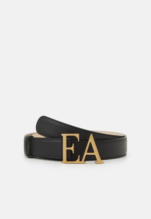 Sort læderbælte med store gyldne bogstaver "EA" som spændet, vist sammenrullet på en hvid overflade.