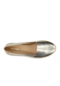 Ploché stříbrné boty na slip-on s hladkou koženou svrchní částí, kulatou špičkou a prošívanými okraji. Interiér má béžové podšívky a logo.