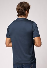 Marineblå kortærmet t-shirt lavet af glat stof, med rund halsudskæring og lige kant, med minimale sømme og uden synlig branding.