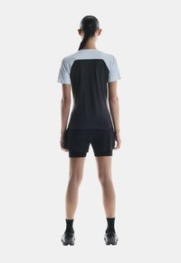 T-shirt de sport noir et bleu clair à manches courtes, associé à un short noir. Le tissu semble léger, lisse et ajusté.