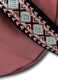 Leren tas in een gedempt rozenkleur met een gegoten afwerking. Voorzien van een patroonriem met geometrische vormen in mint en pink op een zwarte achtergrond.