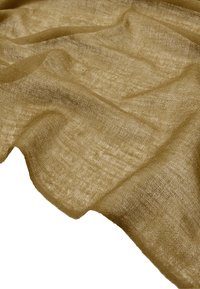 Jasnobrązowa, teksturowana tkanina ułożona w miękkie fałdy, ukazująca przezroczysty wzór plecenia oraz nieco nieregularną powierzchnię.