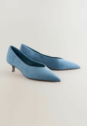 Pompes pointues en daim bleu avec un petit talon kitten. Texture lisse, design minimaliste et silhouette élégante.