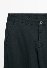 Pantaloni neri realizzati in tessuto leggero, con frontale piatto, tasche laterali e chiusura con un singolo bottone in vita.