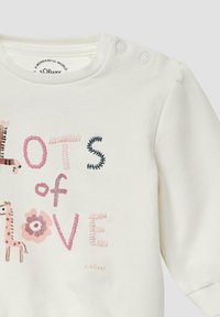 Wit baby shirt met drukknopen op de schouder, versierd met gestikte roze en zwarte tekst "Veel liefde" en illustraties van een giraffe en bloemen.