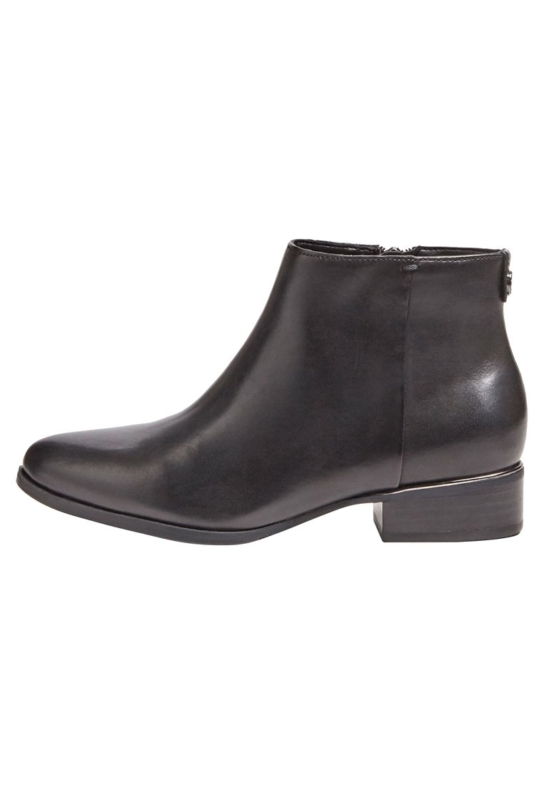 Bottine en cuir noir à talon bloc bas, fermeture éclair latérale et bout arrondi, vue de profil sur fond blanc.