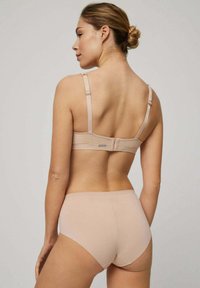 Conjunto de sujetador y braguita en beige claro, con tela suave y elástica, tirantes ajustables y cierre de gancho en la parte posterior.