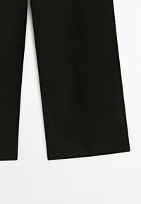 Schwarze, weit geschnittene Hosen aus einem glatten Stoff, mit hoher Taille und geradem Schnitt, ohne sichtbare Muster oder Verzierungen.