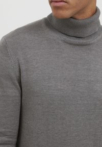 Grauer Rollkragenpullover aus weichem Strickstoff. Verfügt über einen gerippten Kragen und eine glatte Textur, mit enganliegenden Ärmeln und Körper.