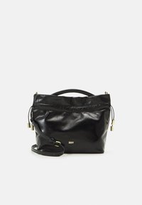 Mustakäsineinen nahkalaukku kiiltävällä pinnalla, joka on suljettu nyörein, varustettuna lyhyellä kahvalla ja irrotettavalla olkahihnalla. Kultaisenväriset metalliosat.