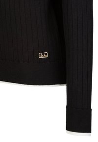 Schwarzer gerippter Pullover aus Strickstoff. Verfügt über ein goldenes Logo mit "1969" auf der unteren linken Seite und weißen Akzenten an den Bündchen und am Saum.