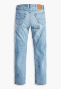 Jean en denim bleu clair vu de dos avec deux poches arrière, une étiquette de marque en cuir sur la ceinture, et des jambes droites.