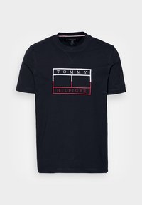 Tmavě modré bavlněné tričko s vyšitým box logem v bílé a červené barvě se textem "TOMMY HILFIGER" uprostřed. Klasický design s kulatým výstřihem.
