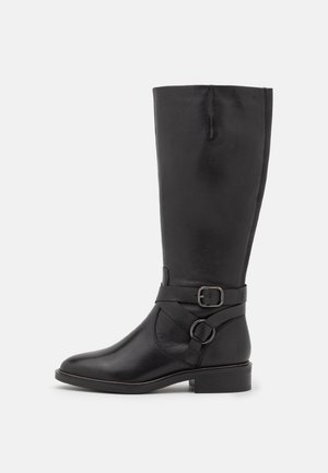 Black leather knee-high boot featuring a side strap with a buckle, rounded toe, and a low block heel, displaying a smooth texture.