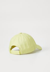 Cappello di cotone giallo, con visiera curva, cinturino regolabile sul retro, cuciture tono su tono, sei fori di ventilazione, texture in tessuto morbido.