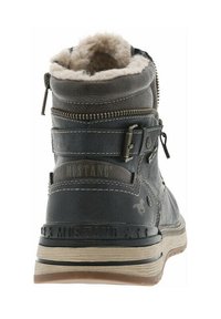Botte chelsea en cuir noir avec doublure en shearling, fermeture éclair latérale et détail de sangle décoratif. Comprend un logo de marque embossé et une semelle texturée.