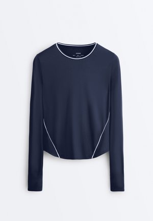 Marineblaues, langärmeliges Sportoberteil mit weißen Paspeln entlang des Ausschnitts und der Seiten, für eine schlanke Passform entworfen.