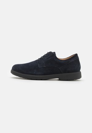 Scarpa in suede blu navy con lacci, punta arrotondata e suola in gomma nera. Presenta cuciture minime e una fodera interna liscia. Design resistente e leggero.