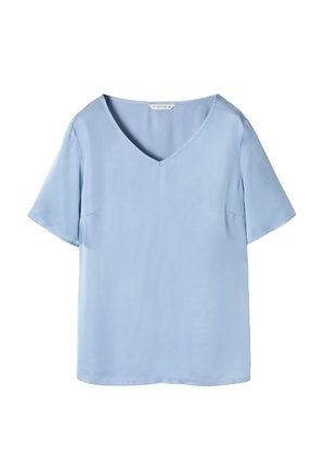 Blouse bleu clair à manches courtes en tissu lisse. Dotée d'un décolleté en V et de deux poches latérales discrètes. Design simple et décontracté.