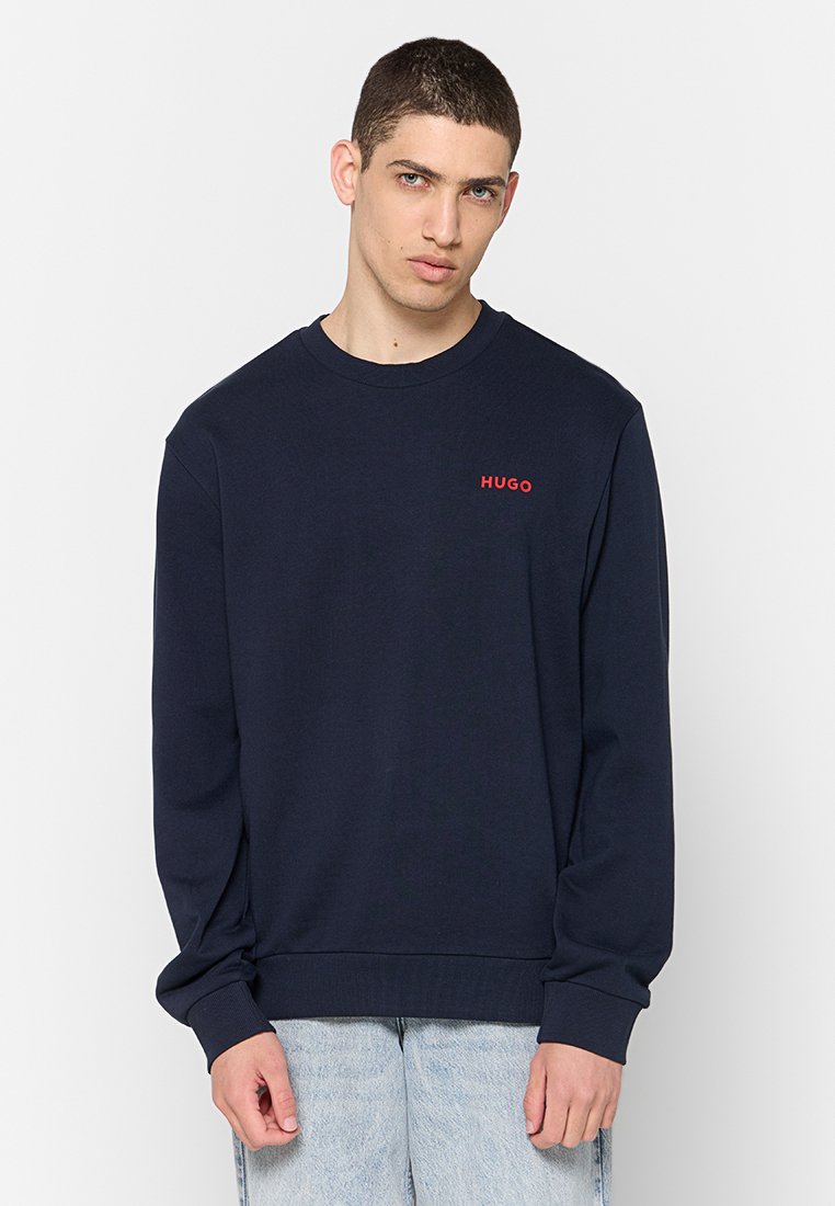 Marineblaue Sweatshirt aus Baumwolle mit rundem Ausschnitt, gerippten Bündchen und dem roten Logo "HUGO" auf der Brust.