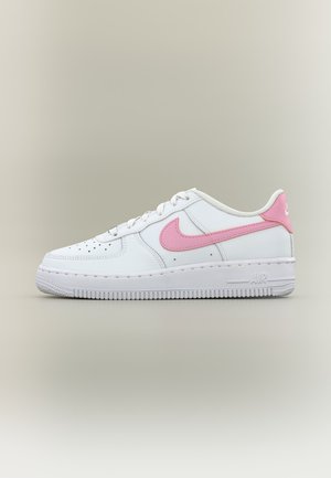 Baskets basses blanches Nike Air Force 1 avec un swoosh rose et une languette au talon, semelle blanche et design lacé sur fond neutre.