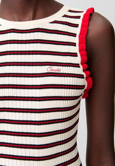 Canotta a maglia a coste con strisce verticali color crema, rosse e nere. Le maniche presentano dettagli arricciati rossi. Include un piccolo logo ricamato "Claudie".