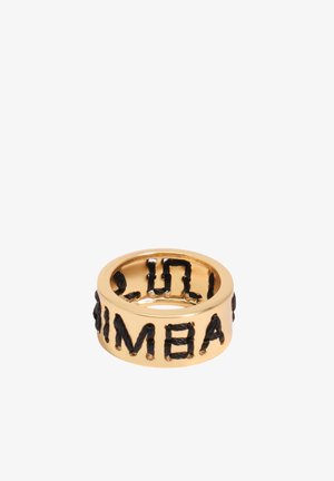 Anillo de banda dorada con letras negras bordadas en relieve formando la palabra "BALENCIAGA" alrededor de su circunferencia.