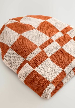 Beanie lavorato a maglia in un motivo a quadri arancione e crema, con una texture morbida e un bordo ripiegato per un maggiore calore.