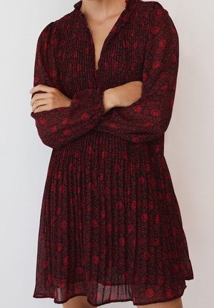 Rode bloemenprintjurk met een geplooid ontwerp, lange mouwen en een ruches halslijn, gemaakt van lichtgewicht stof.