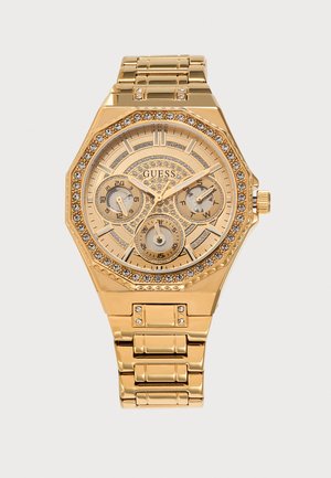 Ρολόι Guess με χρυσή απόχρωση, με κρυστάλλινες λεπτομέρειες, τρεις μικροκαντράν που δείχνουν 24ωρη ώρα, ημέρα και ημερομηνία, και μεταλλικό μπρασελέ με συνδέσμους.