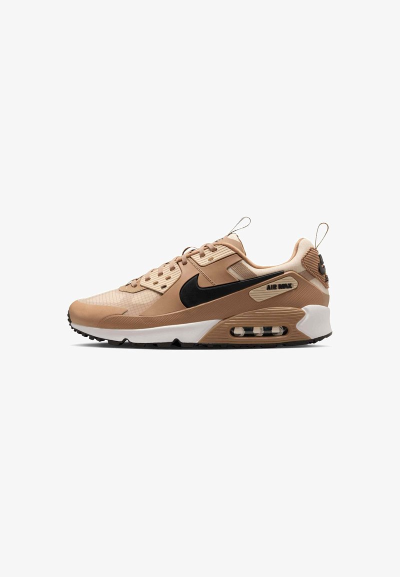 Baskets Nike Air Max beige et marron clair avec un swoosh noir, une semelle blanche, un amorti visible à l'air et un design à lacets, vues de côté.