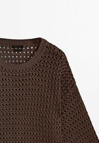 Pull en tricot ouvert marron avec col rond, présentant un motif de tricot détaillé et un col côtelé sur fond blanc.