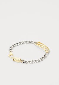Pulsera de cadena plateada con herrajes en tono dorado, que cuenta con un cierre de marca y un panel decorativo dorado. Enlaces texturizados y acabado pulido.