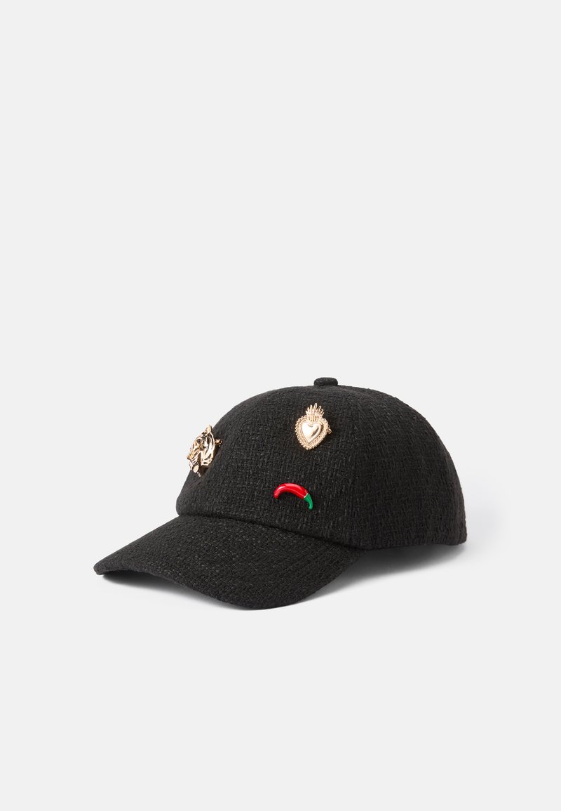 Gorra negra con una tela texturizada, que presenta pines dorados y coloridos de un león, un corazón y un pimiento en el panel frontal.