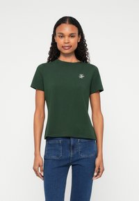 Πράσινο βαμβακερό t-shirt με στρογγυλή λαιμόκοψη και κοντά μανίκια; διαθέτει λευκό κεντητό λογότυπο στην αριστερή πλευρά του στήθους; λεία υφή.