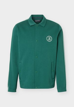 Πράσινο σακάκι με κουμπιά και γιακά, δύο πλαϊνές τσέπες, λευκή ρίγα στα μανίκια και κυκλικό λογότυπο Marc O'Polo στο στήθος.