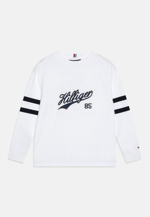 White long-sleeve shirt with black double stripes on sleeves, "Hilfiger" script and "85" printed in navy blue on the front.