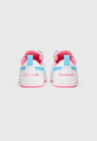 White sneakers with pink accents and light blue details. Features a textile upper and a rubber outsole, adorned with the Reebok logo.