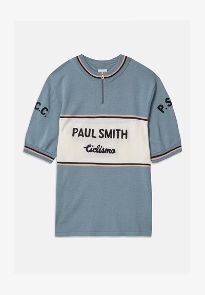 Sininen lyhythihainen neule, jossa on valkoinen vaakasuora nauha. Sisältää "PAUL SMITH" ja "Ciclismo" mustalla tekstillä, reunoissa pinkkejä ja mustia raitoja.