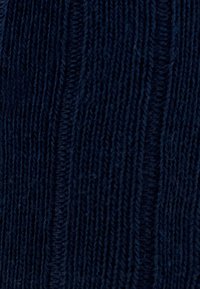 Tissu tricoté bleu marine avec un motif riblé texturé, comportant des lignes verticales et une épaisseur douce, adapté pour des vêtements ou des accessoires.