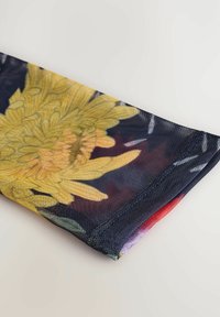 Blommönstrad scarfs med gula blommor på en mörk bakgrund, bestående av ett strukturerat nätmaterial och en kontrasterande färgad kant.