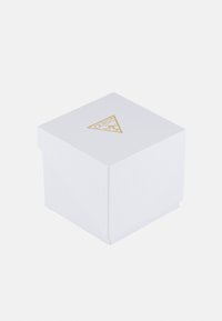 Boîte d'emballage blanche avec une surface texturée, présentant un logo triangulaire doré sur le dessus. De forme carrée avec une fermeture à rabat.