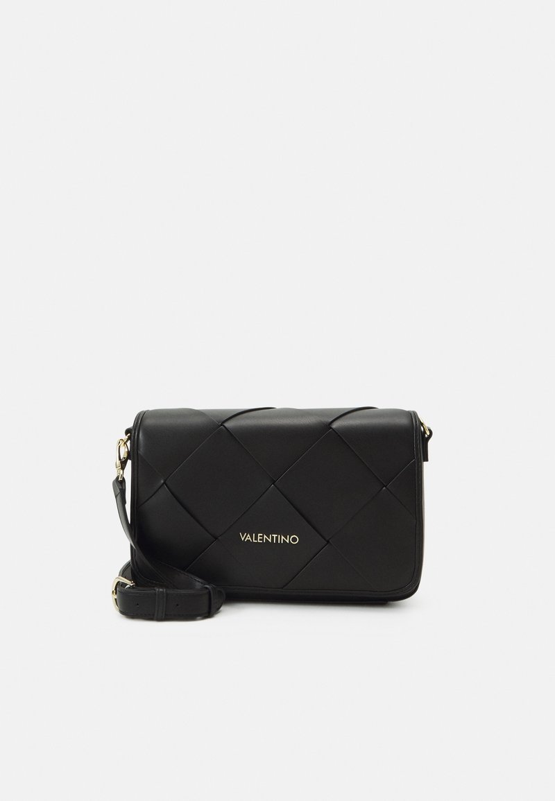 Borsa a tracolla nera in pelle con design trapuntato, logo dorato, tracolla regolabile e forma rettangolare. Presenta una texture liscia e uno stile minimalista.