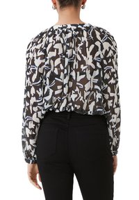 Transparante zwarte blouse met een abstract wit en blauw patroon, wijdvallende mouwen en geplooide details bij de halslijn en op de rug.