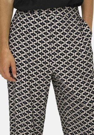 Pantalons à motifs crème avec un design floral noir, dotés d'une taille haute, de jambes larges et de poches latérales. Texture de tissu lisse.