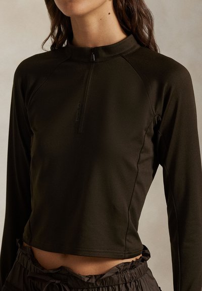 Σκούρο πράσινο μακρυμάνικο τοπ με ψηλό γιακά και κλείσιμο με φερμουάρ, κατασκευασμένο από λείο, ελαστικό υλικό, με ραγκλάν μανίκια και κοντό σχεδιασμό.