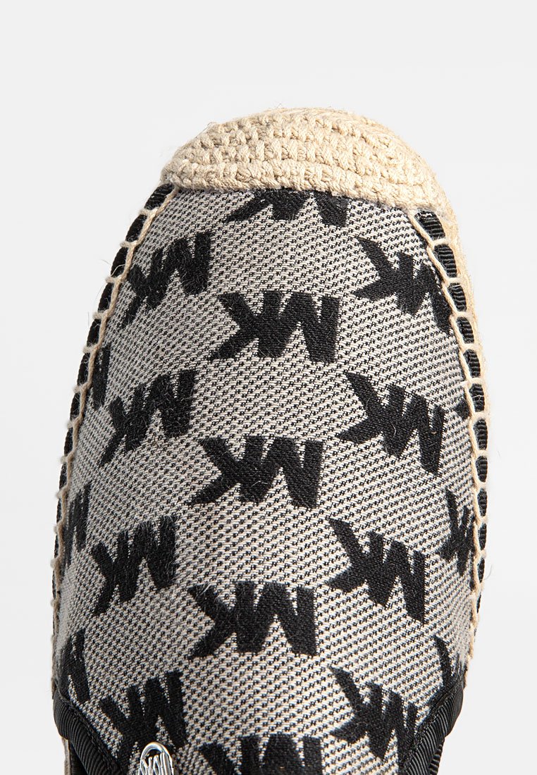 Espadriglia piatta con tomaia in tessuto intrecciato che presenta un motivo "MK" nero su uno sfondo grigio chiaro. Bordo in juta naturale sulla punta.